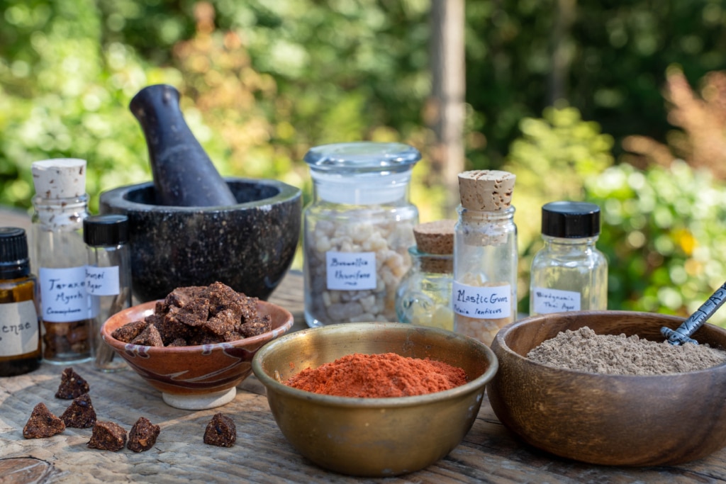 27_03_23 Kyphi Ingredients 4.jpg 04152024 copy table with bowls and jars full of incense ingredients, powders and resins