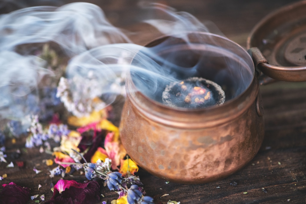lavender and rose petals burning on an incense charcoal in incense burner lavender and rose petals burning on an incense charcoal in a copper incense burner