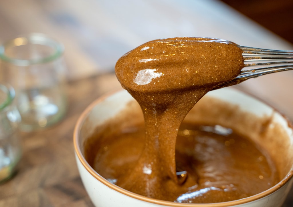 herbal honey electuary dripping from whisk into bowl